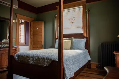 a bedroom with a four poster bed and a window at Elk River Hotel in Sutton