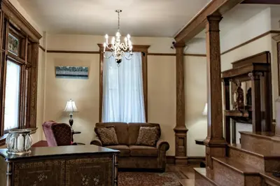 a living room with a chair and a chandelier at Elk River Hotel in Sutton