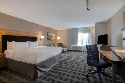 a hotel room with a bed and a desk and a computer at TownePlace Suites by Marriott Monroe in Monroe