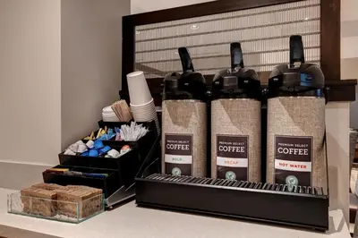 a group of four bottles of coffee on a shelf at TownePlace Suites by Marriott Monroe in Monroe