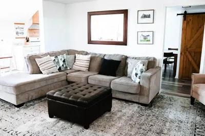 a living room with a couch and a chair at Cordova Farmhouse - 7 Minutes from the Ark! in Williamstown