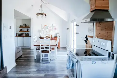 a kitchen with a table and a stove top oven at Cordova Farmhouse - 7 Minutes from the Ark! in Williamstown