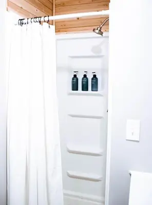 a white shower curtain in a bathroom with two bottles of water at Cordova Farmhouse - 7 Minutes from the Ark! in Williamstown