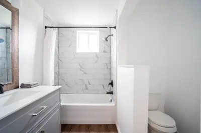 a white bathroom with a tub and a toilet at Cordova Farmhouse - 7 Minutes from the Ark! in Williamstown