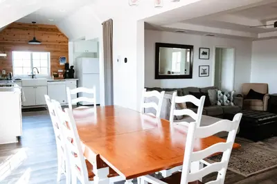 a kitchen and living room with a wooden table and chairs at Cordova Farmhouse - 7 Minutes from the Ark! in Williamstown