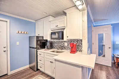 a kitchen with white cabinets and a red appliance at Updated Williamstown Apartment with Kitchen! in Williamstown