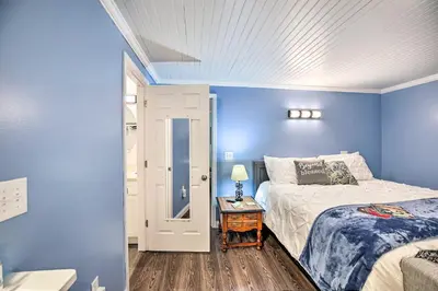 a bedroom with blue walls and a bed and a table at Updated Williamstown Apartment with Kitchen! in Williamstown