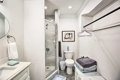 a white bathroom with a shower and a toilet at Updated Williamstown Apartment with Kitchen! in Williamstown