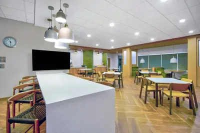 a dining room with tables and chairs and a tv at Fairfield by Marriott Inn & Suites Cincinnati North West Chester in West Chester