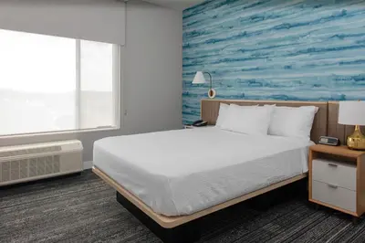 a bedroom with a bed and a blue wall at TownePlace Suites By Marriott Dayton Wilmington in Wilmington