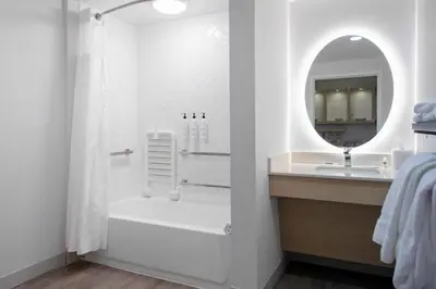 a bathroom with a tub and a sink and a mirror at TownePlace Suites By Marriott Dayton Wilmington in Wilmington