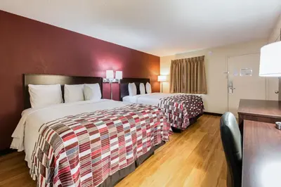 a hotel room with two beds and a desk at Red Roof Inn Marion, IN in Marion