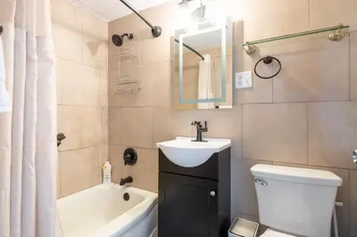 a bathroom with a sink and a toilet and a bath tub at Georgetown Villas 2-1c King and Queen Bedrooms ideal for long stays! in Fairview Park