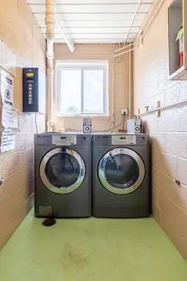 two washing machines in a laundry room with a window at Georgetown Villas 2-1c King and Queen Bedrooms ideal for long stays! in Fairview Park