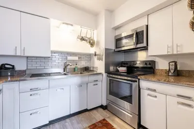 a kitchen with white cabinets and stainless steel appliances at Georgetown Villas 2-1c King and Queen Bedrooms ideal for long stays! in Fairview Park