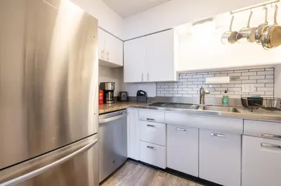 a kitchen with white cabinets and a stainless steel refrigerator at Georgetown Villas 2-1c King and Queen Bedrooms ideal for long stays! in Fairview Park