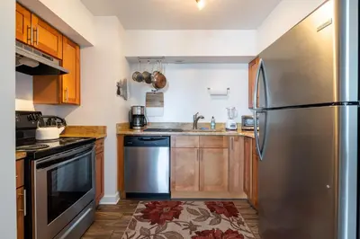 a kitchen with a stainless steel refrigerator and wooden cabinets at Georgetown Villas 3-2c Close to Cleveland Airport and Fairview Hospital ideal for long stays! in Fairview Park