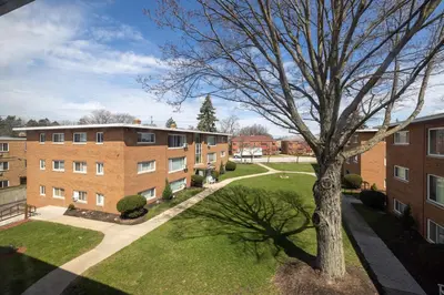 an apartment building with a tree in the yard at Georgetown Villas 3-2c Close to Cleveland Airport and Fairview Hospital ideal for long stays! in Fairview Park