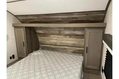 a bedroom with a bed and a wooden wall at Cadiz Motel by OYO on route 250 in Cadiz