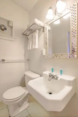 a white bathroom with a toilet and a sink at Cadiz Motel by OYO on route 250 in Cadiz