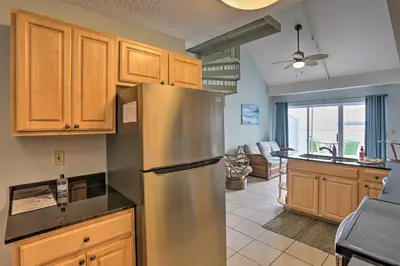 a kitchen with a stainless steel refrigerator and a living room at Resort-Style Condo with Lake-View Balcony! in Put-in-Bay