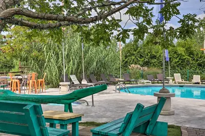 a pool with green chairs and a table and chairs at Resort-Style Condo with Lake-View Balcony! in Put-in-Bay