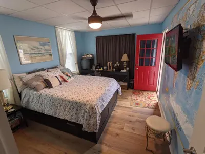 a bedroom with a bed and a red door at The Estate Studio in Downtown Milford in Milford