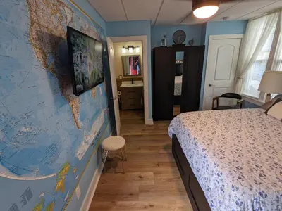 a bedroom with a large map of the world on the wall at The Estate Studio in Downtown Milford in Milford