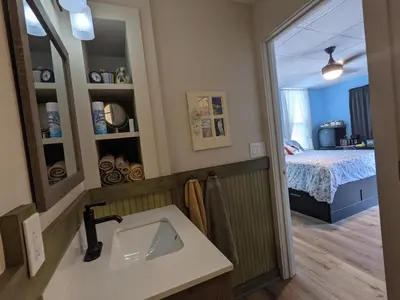 a bathroom with a sink and a bedroom with a bed at The Estate Studio in Downtown Milford in Milford