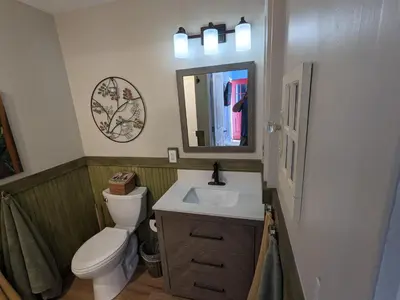 a bathroom with a toilet and a sink and a mirror at The Estate Studio in Downtown Milford in Milford