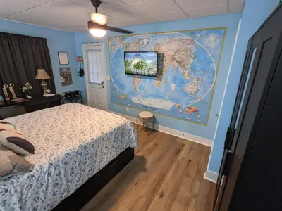 a bedroom with a map of the world on the wall at The Estate Studio in Downtown Milford in Milford