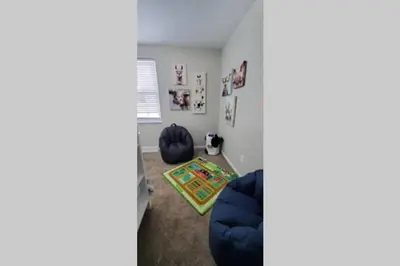 a living room with a blue couch and a rug at Cindy's Super Ranch Home in West Chester