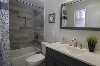 a bathroom with a sink and a toilet and a mirror at Cindy's Super Ranch Home in West Chester
