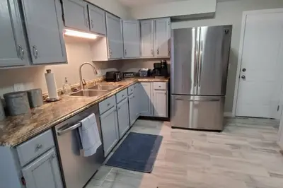 a kitchen with white cabinets and a stainless steel refrigerator at Cindy's Super Ranch Home in West Chester