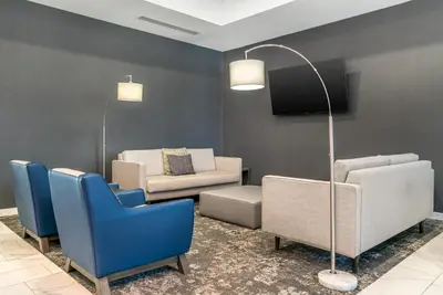 a living room with blue chairs and a floor lamp at Comfort Inn & Suites Adrian in Adrian