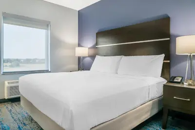 a large bed in a hotel room with a window at Comfort Inn & Suites Adrian in Adrian
