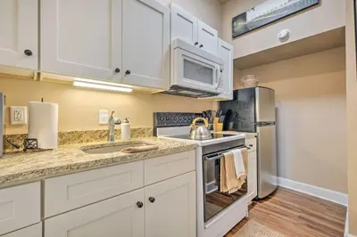 a kitchen with white cabinets and a sink at Quaint Apartment in Historic Georgetown! in Georgetown