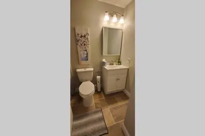 a bathroom with a toilet and a sink and a mirror at Lacinda's Cozy Home in Beckett Ridge