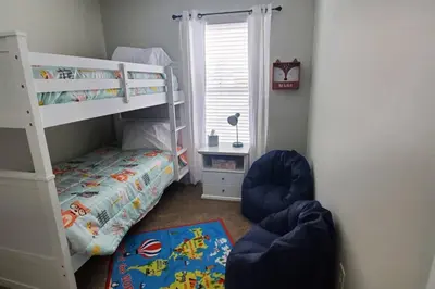 a small bedroom with a bunk bed and a chair at Lacinda's Cozy Home in Beckett Ridge