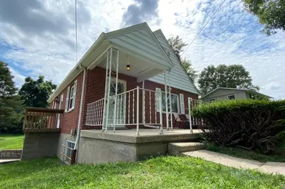 a red brick house with a large front porch at Nikki's House in Cincinnati