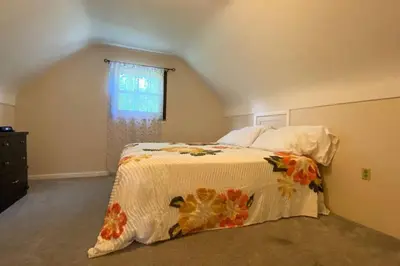 a bedroom with a bed with a floral bedspread at Nikki's House in Cincinnati