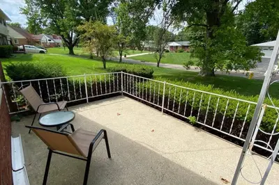 a patio with two chairs and a table and a fence at Nikki's House in Cincinnati
