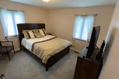 a bedroom with a bed and a flat screen tv at Nikki's House in Cincinnati
