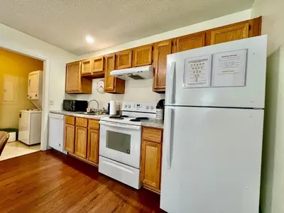 a kitchen with a white refrigerator and wooden cabinets at Lennie's House Near the Lake in Monroe