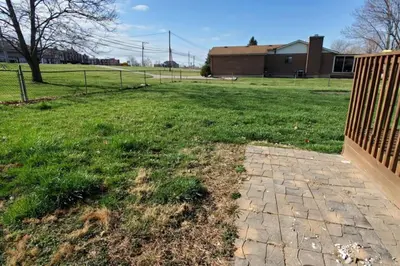 a yard with a fence and a grass field at Pet Friendly Home with Fenced in Yard in Bethany
