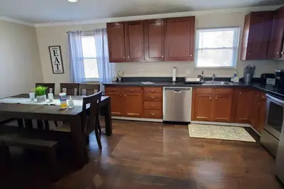 a kitchen with wooden cabinets and a table with a dining room at Pet Friendly Home with Fenced in Yard in Bethany