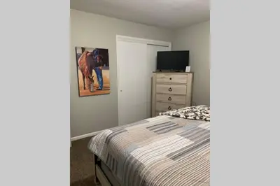 a bedroom with a bed and a dresser with a television at West Chester Mason Home Near Kings Island in Pisgah