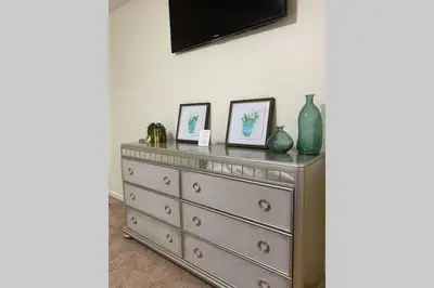 a dresser with three pictures on top of it at Bailee's House in Monroe in Monroe