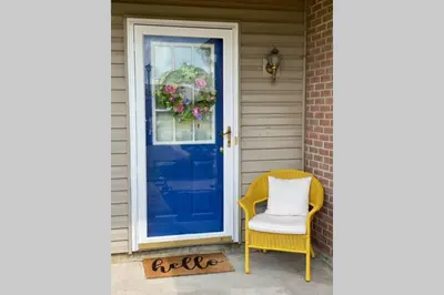 a yellow chair and a blue door on a house at Bailee's House in Monroe in Monroe