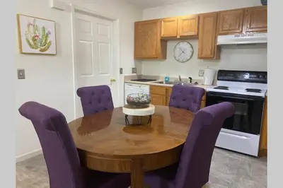a kitchen with a wooden table and purple chairs at Bailee's House in Monroe in Monroe